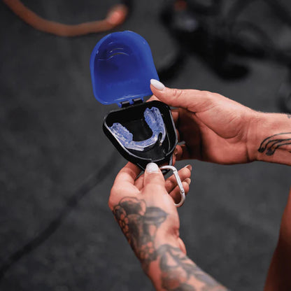 image of someone with tattooed arms holding the rx1 recovery mouthpiece.